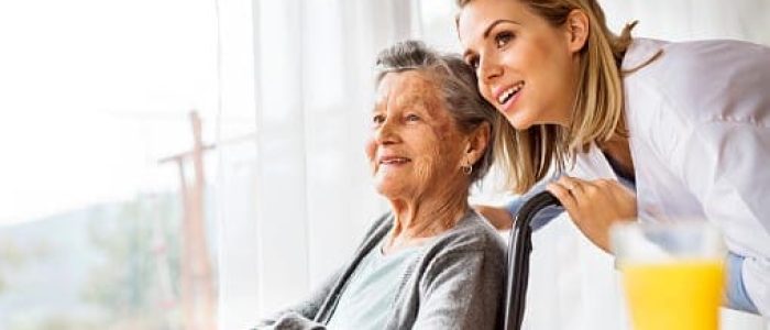Health visitor and a senior woman during home visit.